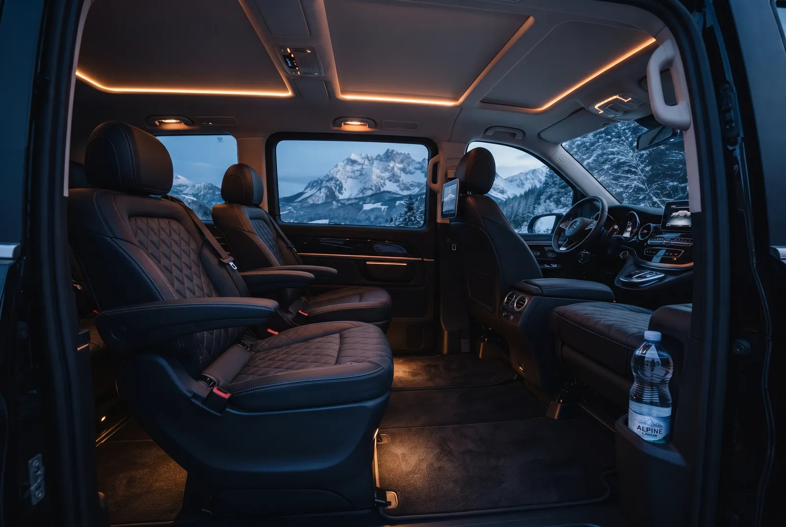 The leather interior of a Mercedes-Benz V-Class, with snow-capped mountains visible through the window.