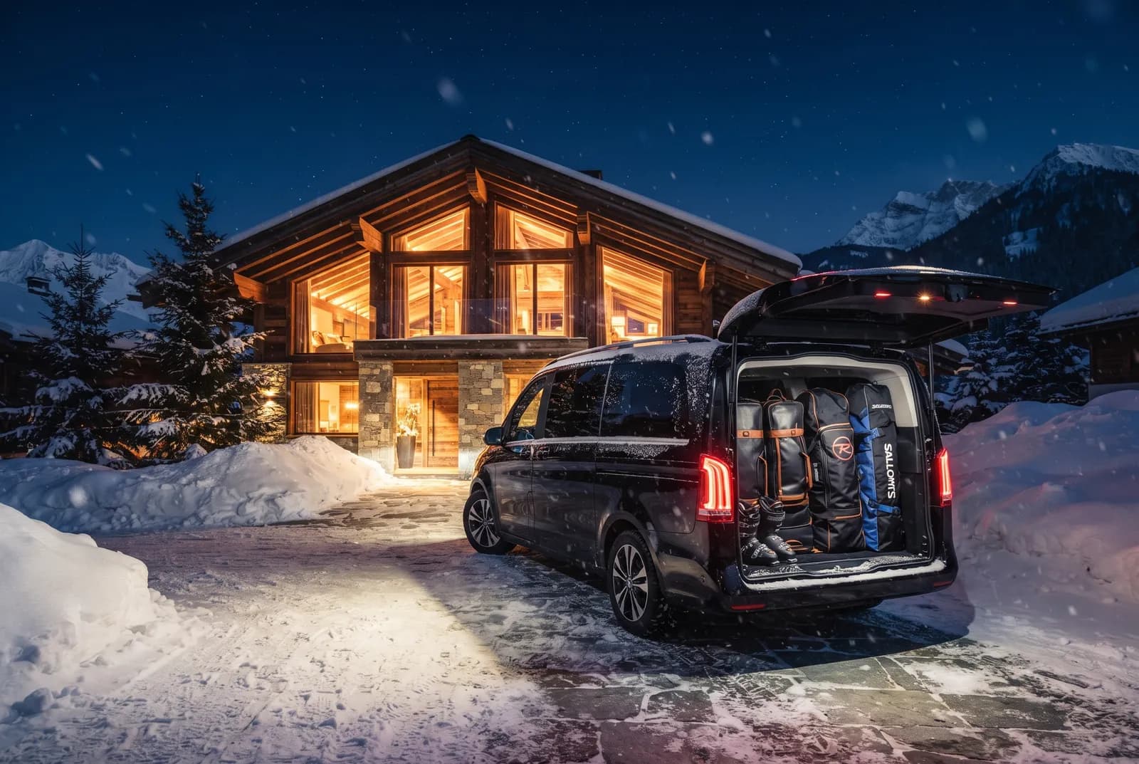 A chauffeur vehicle arriving at an illuminated Alpine chalet in the evening.